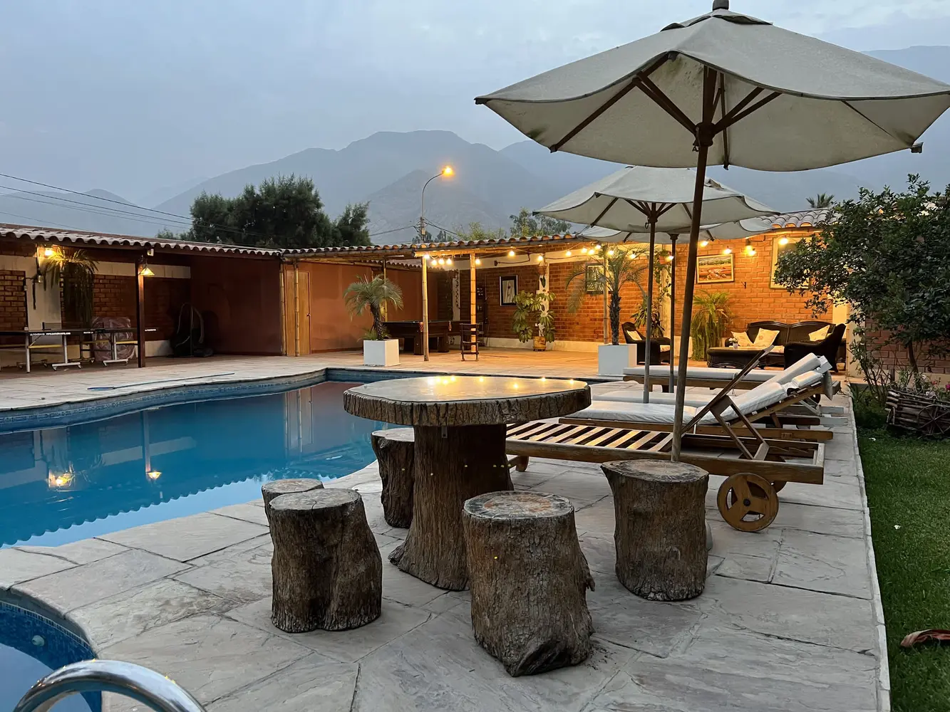 Piscina con cobertor térmico y tumbonas de madera