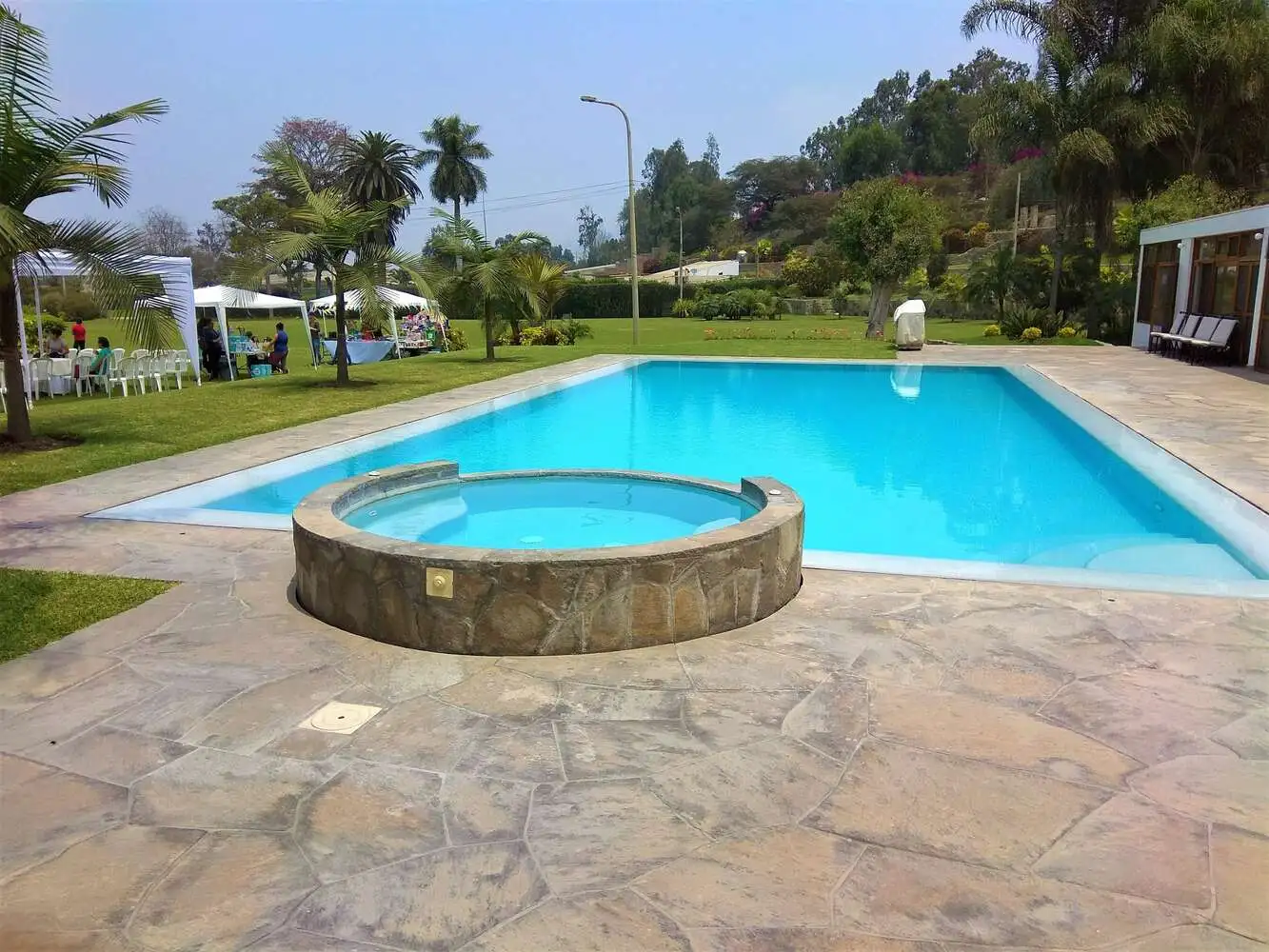 Piscina con cobertor térmico y tumbonas de madera
